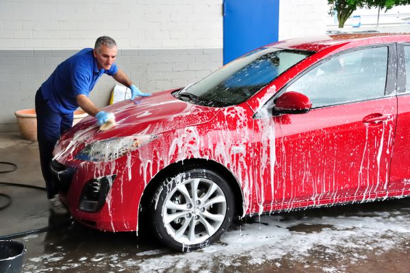 ein Mann wäscht sein Auto