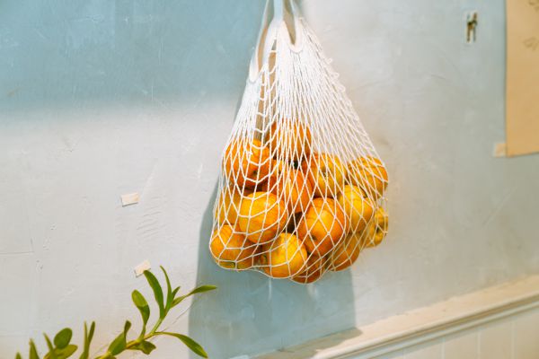 ein Netz mit Orangen hängt an der Wand