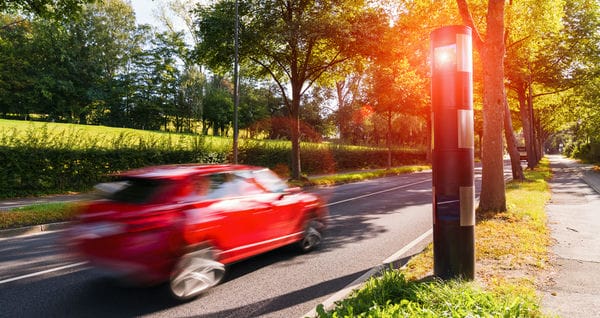 ein Auto fährt an einem Blitzer vorbei