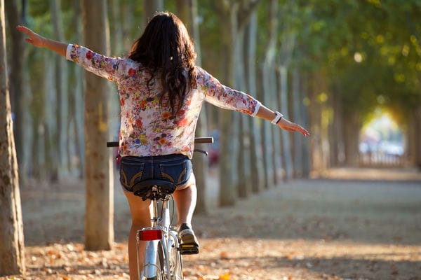 eine Frau fährt freihändig mit dem Fahrrad