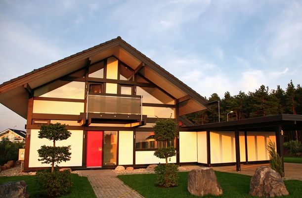 ein Einfamilienhaus mit Carport und grüner Wiese