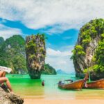 Urlauberin sitzt am Strand in Thailand und genießt die Aussicht.