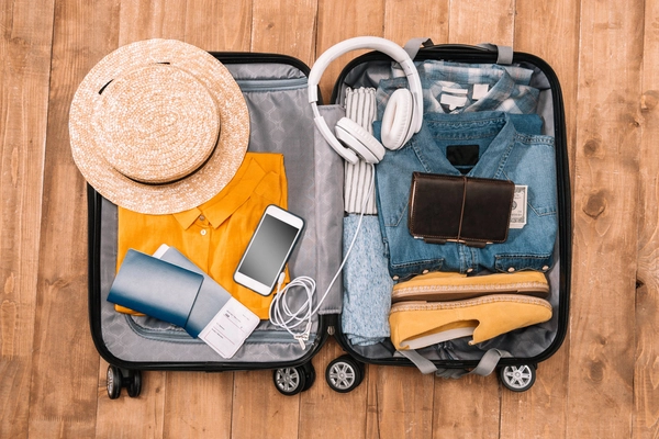 Ein offener Koffer für die Sommerferien wird gepackt