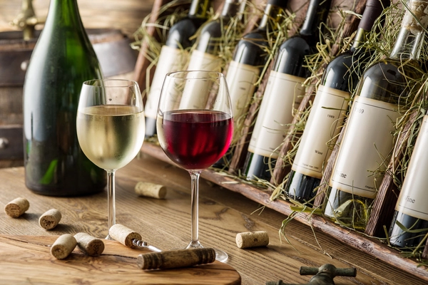 zwei Gläser mit Weißwein und Rotwein stehen auf einem Tisch
